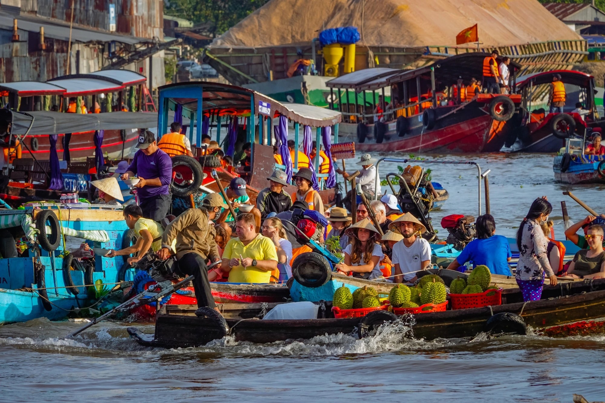 Cai Rang Floating Market bursts to life at dawn, with boats piled high with fruits, local treats, and the vibrant rhythm of river trade in the Mekong Delta